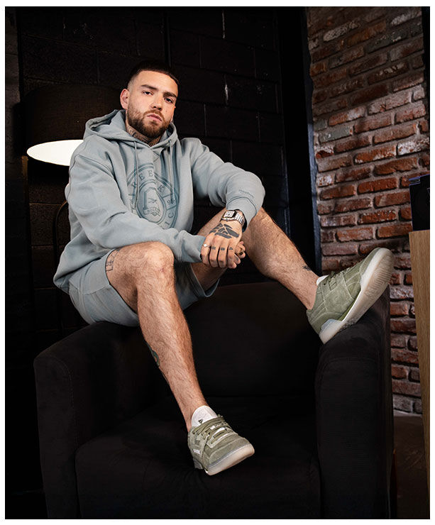 Yoiker usando hoodie deportiva gris Reebok con logo cl&aacute;sico, estilo urbano lifestyle.