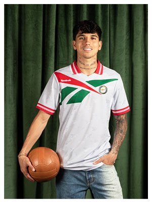 Card Reebok Jerseys Retro con Kevin Alvarez en jersey blanco con detalles verdes y rojos, sosteniendo bal&oacute;n vintage.
