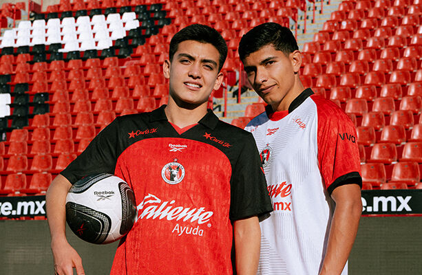 Futbolistas Gilberto Mora y Kevin Casta&ntilde;eda modelan los nuevos uniformes Reebok de Xolos de Tijuana en el estadio Caliente.