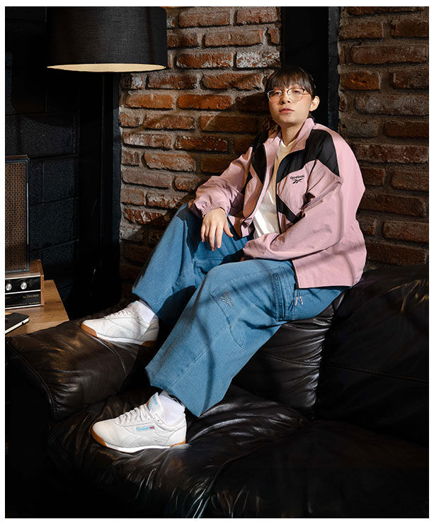 Azuky con chamarra deportiva Reebok rosa con vector en negro.