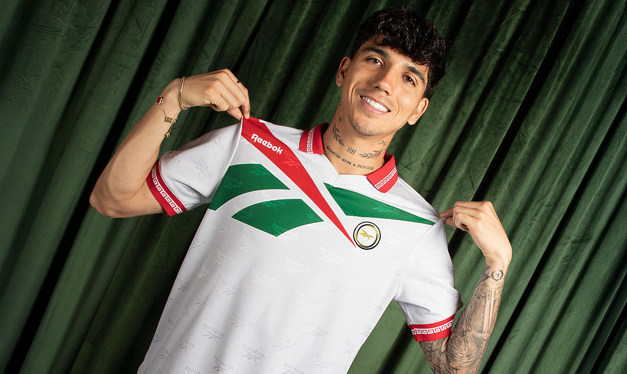 Carrusel Reebok Jerseys Retro con Kevin Alvarez mostrando jersey blanco con detalles verdes y rojos, escudo retro, ribs con grecas y fondo cortina verde.