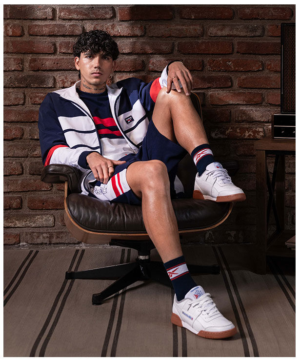 Kevin &Aacute;lvarez con chamarra deportiva Reebok para hombre, look urbano y estilo cl&aacute;sico deportivo.