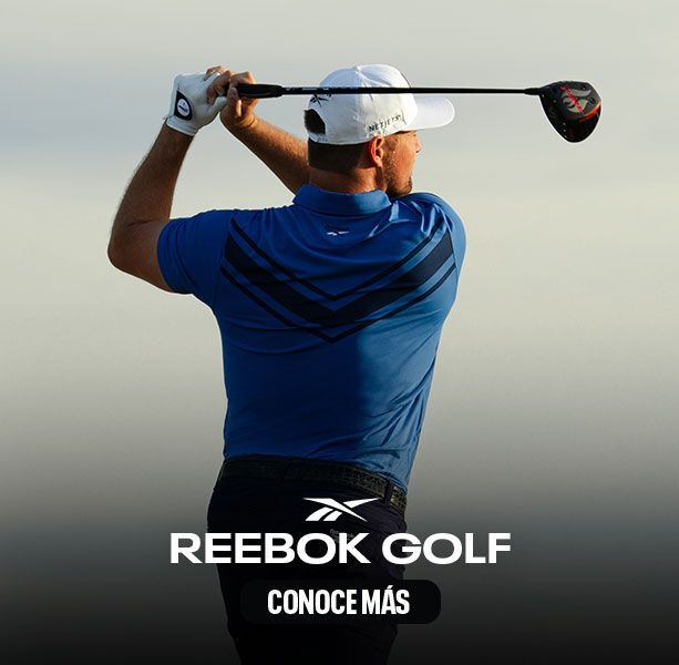 Modelo Reebok Golf de espaldas en polo azul con detalles oscuros, gorra azul, swing con hierro, fondo de &aacute;rboles y vegetaci&oacute;n.