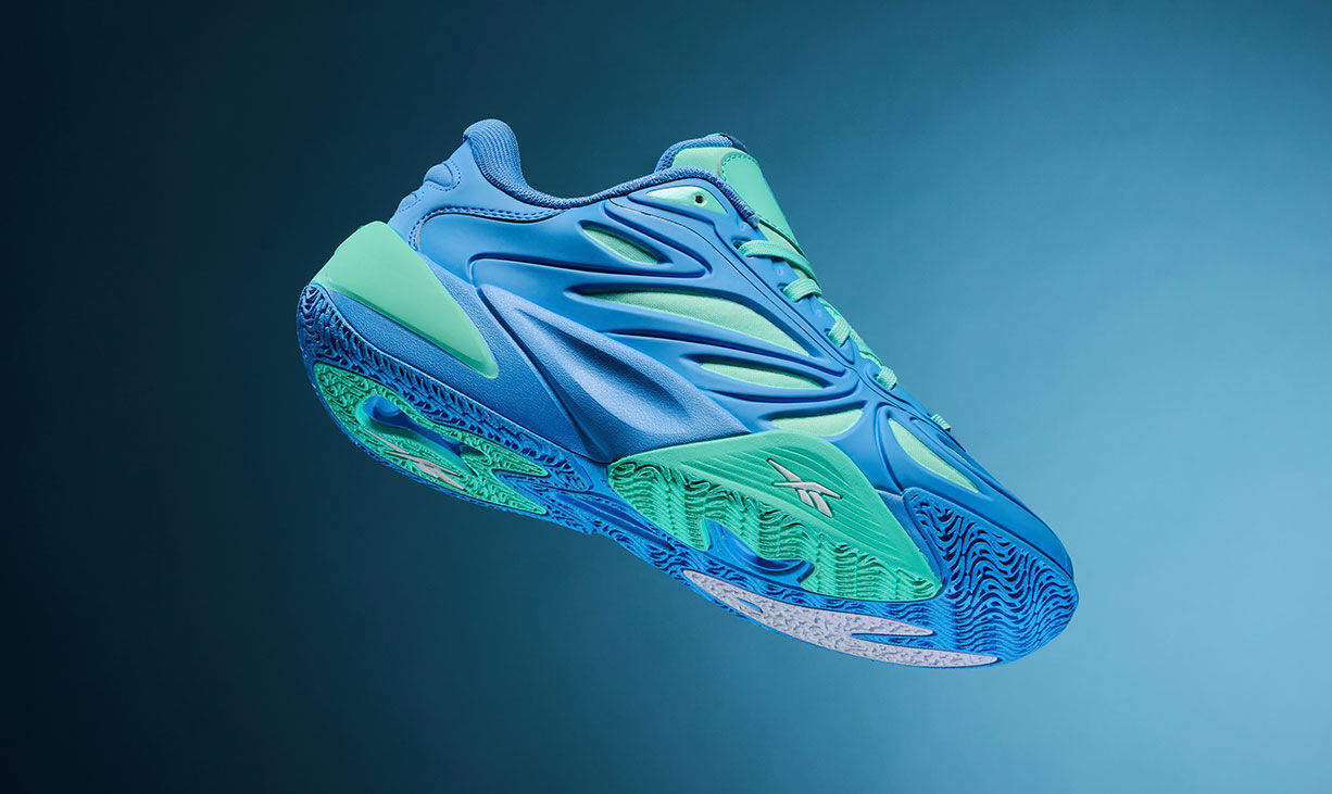 Carrusel producto Reebok Angel Reese 1 con tenis de basketball en &aacute;ngulo din&aacute;mico, tonos azul el&eacute;ctrico y verde menta, detalle de suela con tracci&oacute;n texturizada, paneles de ventilaci&oacute;n y logo Reebok vector sobre fondo degradado azul oscuro a claro