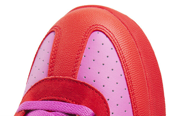 Detalle macro de la puntera del tenis Reebok x IceCream Board Flip en combinaci&oacute;n rosa y rojo con perforaciones, costuras reforzadas, cordones morados, acabado de nobuck y piel texturizada.