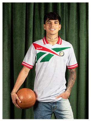 Card Reebok Jerseys Retro con Kevin Alvarez en jersey blanco con detalles verdes y rojos, sosteniendo bal&oacute;n vintage.