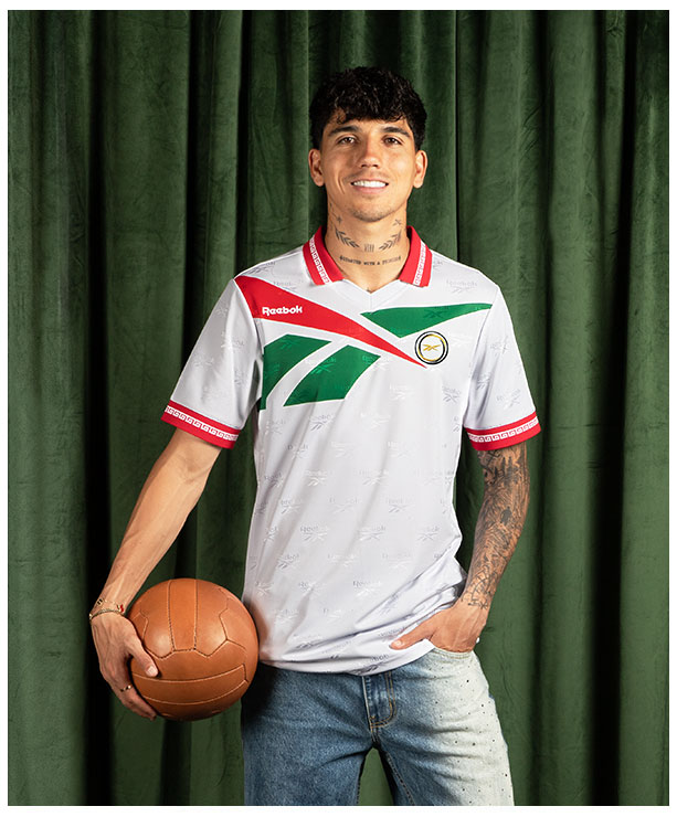 Card Reebok Jerseys Retro con Kevin Alvarez en jersey blanco con detalles verdes y rojos, sosteniendo bal&oacute;n vintage.